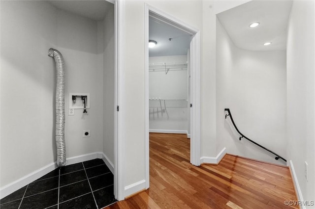 hallway with baseboards, wood finished floors, an upstairs landing, and recessed lighting