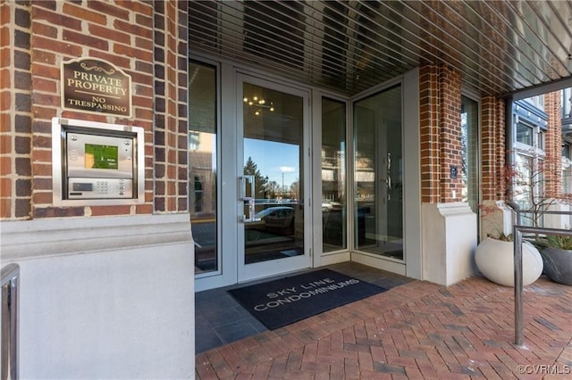 view of exterior entry featuring brick siding