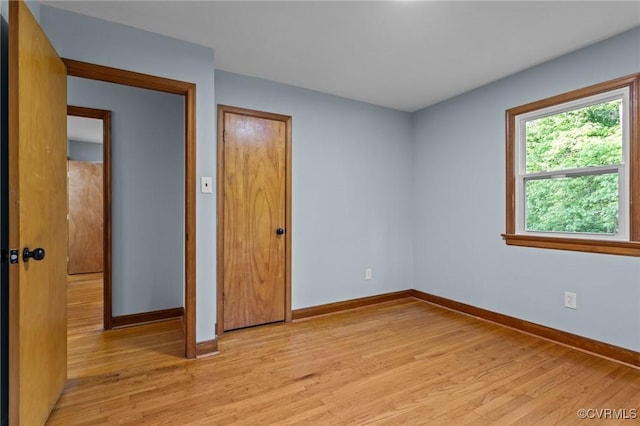 spare room featuring light wood-style floors and baseboards