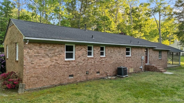 back of house with a shingled roof, brick siding, crawl space, central air condition unit, and a lawn