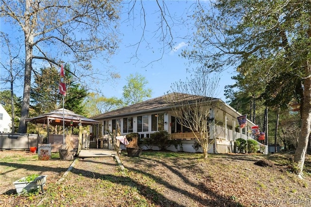 rear view of house featuring a covered hot tub and a gazebo