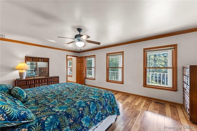 bedroom featuring light wood finished floors, baseboards, visible vents, ceiling fan, and crown molding