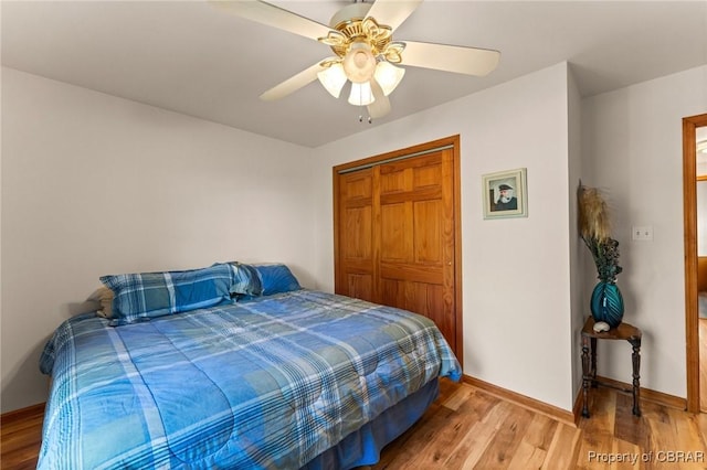 bedroom with light wood-style flooring, baseboards, a closet, and ceiling fan