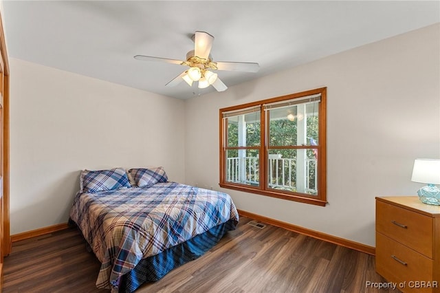bedroom featuring ceiling fan, baseboards, and dark wood-style flooring