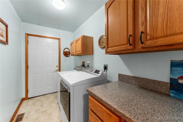 clothes washing area with washer and dryer, baseboards, and cabinet space