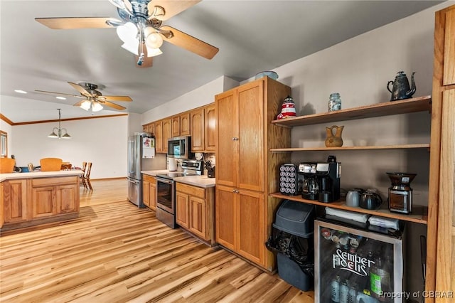 kitchen with light wood finished floors, a ceiling fan, brown cabinets, and appliances with stainless steel finishes
