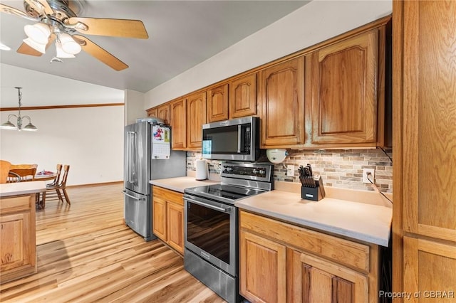 kitchen featuring backsplash, appliances with stainless steel finishes, light wood-style floors, and light countertops