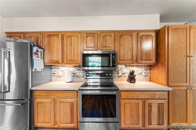 kitchen featuring light countertops, decorative backsplash, and stainless steel appliances