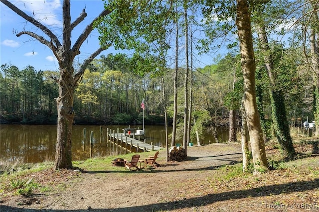 exterior space featuring a boat dock, a forest view, and a water view