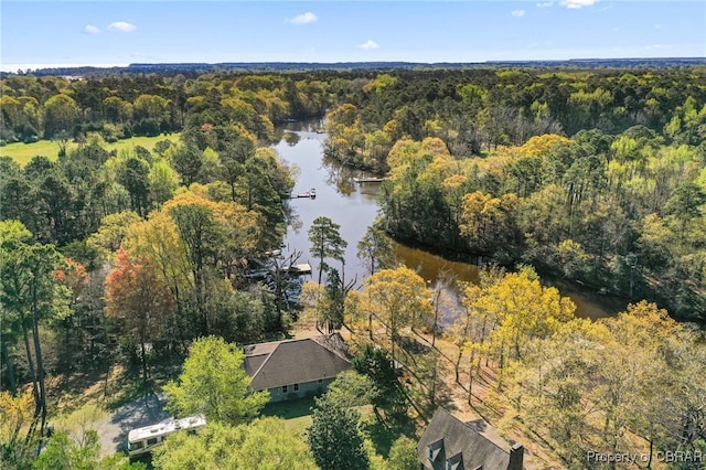 drone / aerial view with a forest view and a water view