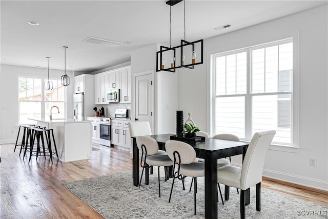 2909 P St, Richmond, VA 23223 - dining room with light wood-style floors, visible vents, baseboards, and a notable chandelier