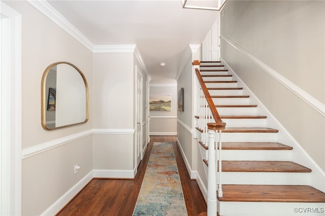 stairway with crown molding, baseboards, and wood finished floors