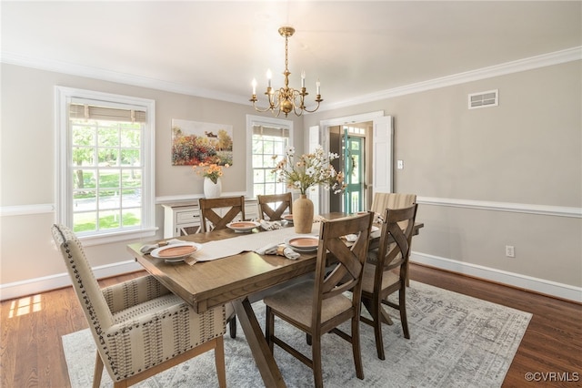 dining room featuring crown molding, a notable chandelier, wood finished floors, and visible vents