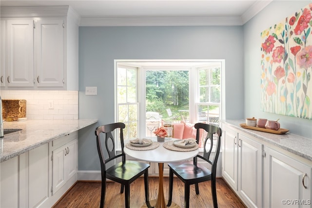 dining area with crown molding, baseboards, and wood finished floors