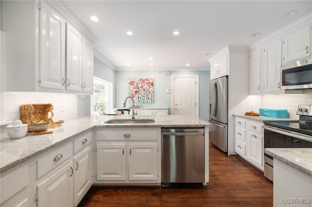 kitchen with a sink, white cabinets, stainless steel appliances, and a peninsula