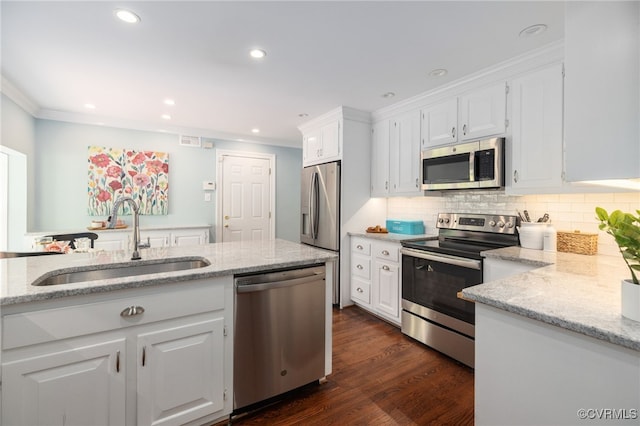 kitchen with crown molding, light stone countertops, white cabinets, a sink, and appliances with stainless steel finishes