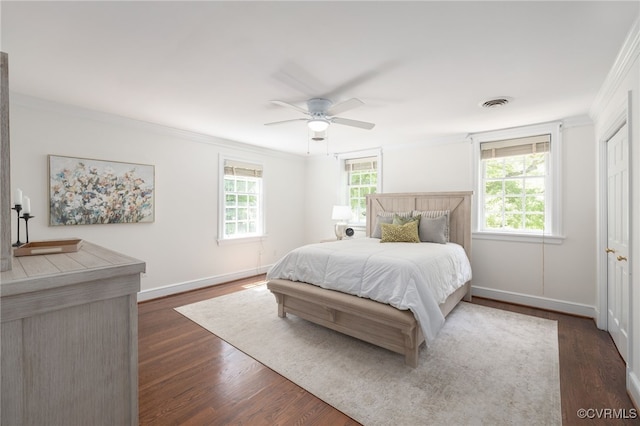 bedroom with visible vents, ornamental molding, baseboards, a ceiling fan, and dark wood finished floors
