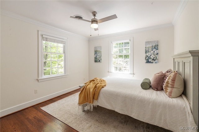 bedroom featuring crown molding, baseboards, multiple windows, and wood finished floors