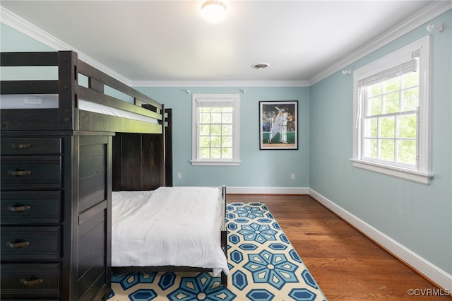 bedroom featuring baseboards, ornamental molding, and multiple windows