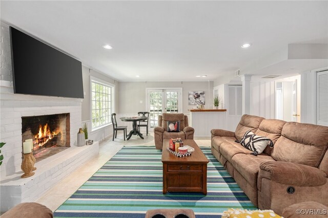 living room featuring a brick fireplace, recessed lighting, and tile patterned flooring