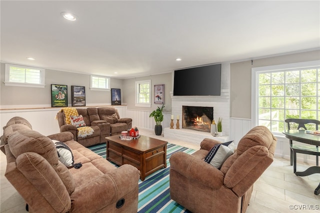 living room featuring wainscoting, recessed lighting, light tile patterned flooring, and a brick fireplace