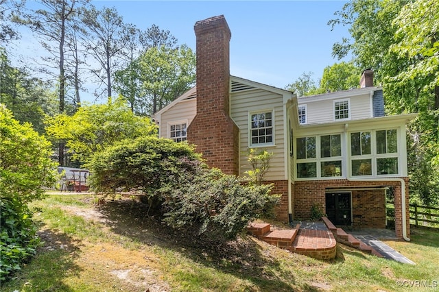 back of house with fence, a chimney, a patio area, and brick siding
