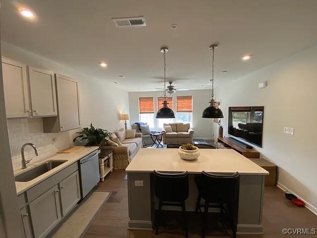 1900 Roseneath Rd Unit 4B, Richmond, VA 23230 - kitchen featuring visible vents, a kitchen island, light countertops, a sink, and dishwasher
