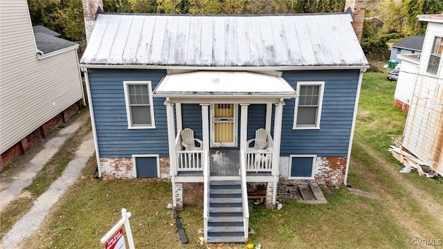 734 Harrison St, Petersburg, VA 23803 - view of front of house featuring a chimney, a front yard, and metal roof