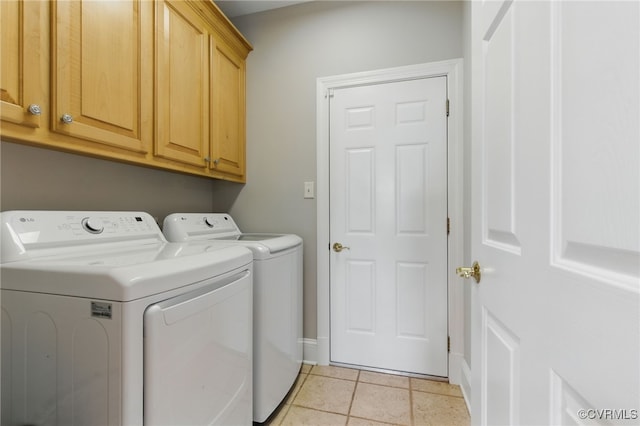 washroom with cabinet space, baseboards, light tile patterned floors, and washer and clothes dryer