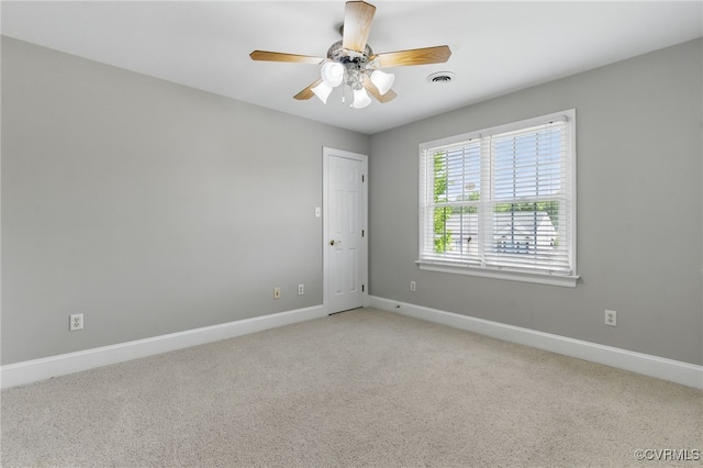 carpeted empty room featuring ceiling fan, baseboards, and visible vents