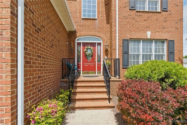 view of exterior entry featuring brick siding