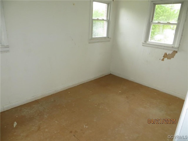 spare room with plenty of natural light and baseboards