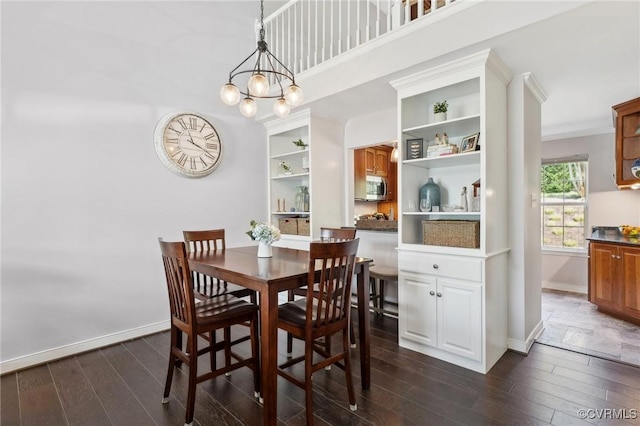 dining area with baseboards, ornamental molding, a chandelier, and dark wood-type flooring