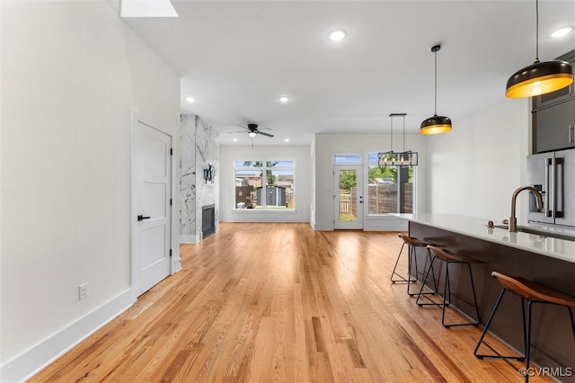 810 N 32nd St, Richmond, VA 23223 - kitchen with a sink, high end fridge, a breakfast bar, light wood-style floors, and light countertops