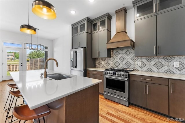 810 N 32nd St, Richmond, VA 23223 - kitchen featuring stainless steel appliances, premium range hood, a sink, a kitchen bar, and light wood-style floors