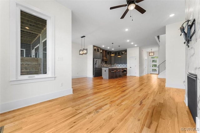 810 N 32nd St, Richmond, VA 23223 - unfurnished living room featuring a ceiling fan, stairway, recessed lighting, light wood-style floors, and baseboards