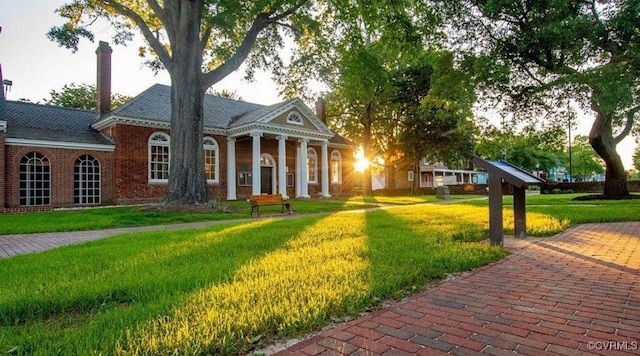 neoclassical home featuring a front yard