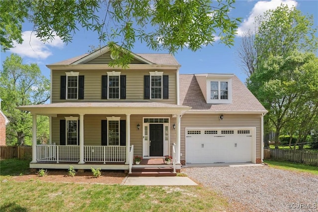 view of front facade with fence, gravel driveway, covered porch, and a garage