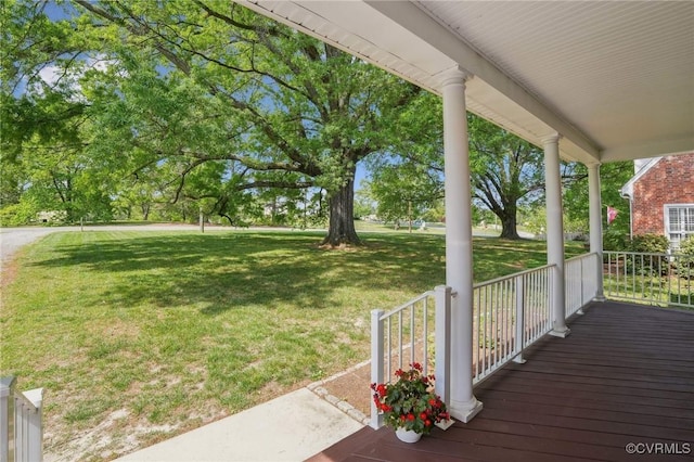 wooden deck featuring a porch and a yard