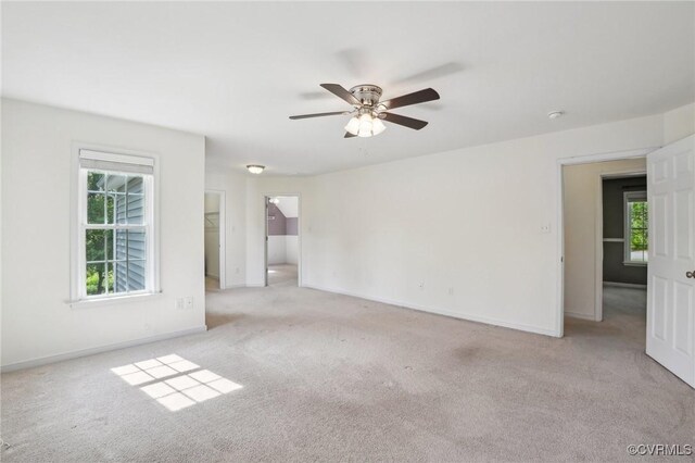 carpeted spare room with baseboards and ceiling fan