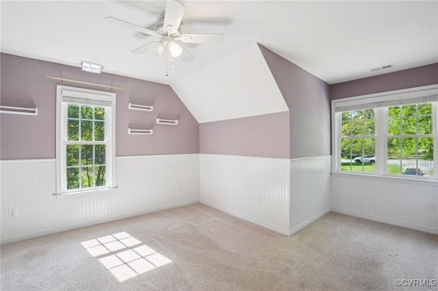 bonus room featuring a wainscoted wall, visible vents, carpet, and ceiling fan