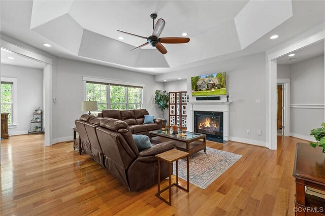 12712 Dell Hill Ct, Chesterfield, VA 23831 - living area featuring a fireplace with flush hearth, a ceiling fan, a tray ceiling, and plenty of natural light