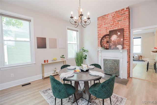 6 S Rowland St, Richmond, VA 23220 - dining area with light wood-style flooring, an inviting chandelier, a fireplace, baseboards, and visible vents