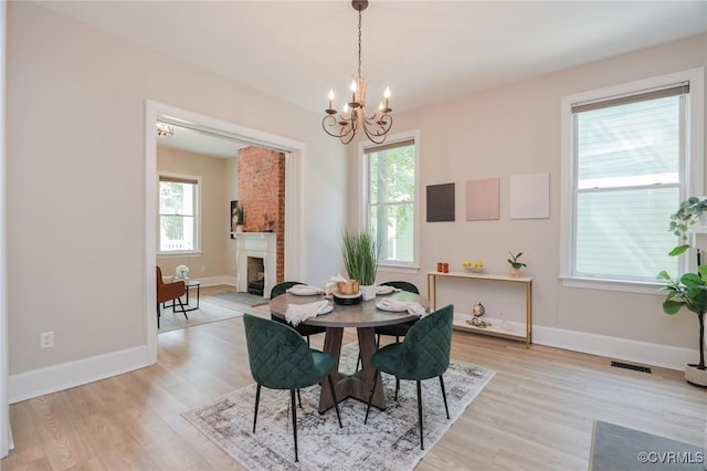 6 S Rowland St, Richmond, VA 23220 - dining area featuring a chandelier, light wood-type flooring, a fireplace, and visible vents