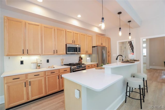 6 S Rowland St, Richmond, VA 23220 - kitchen with light brown cabinetry, a center island with sink, light wood-type flooring, light countertops, and appliances with stainless steel finishes