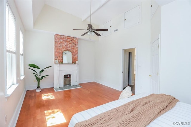 6 S Rowland St, Richmond, VA 23220 - bedroom with baseboards, a fireplace with raised hearth, beamed ceiling, and light wood-style flooring