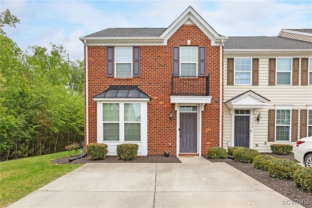 townhome / multi-family property with brick siding and roof with shingles