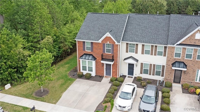 view of front facade featuring roof with shingles and brick siding