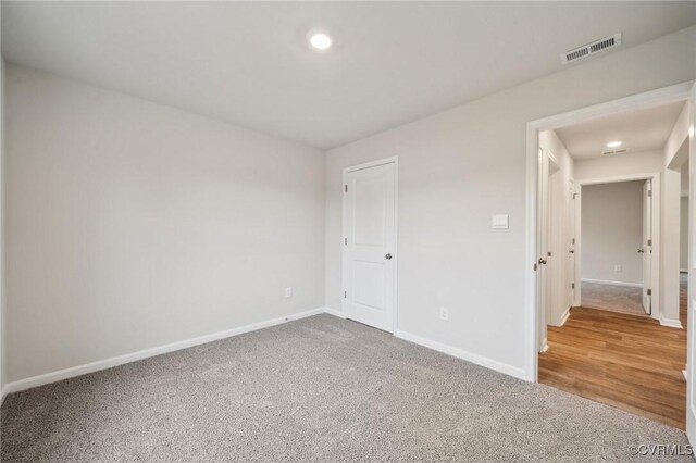 unfurnished bedroom with baseboards, visible vents, carpet floors, and recessed lighting