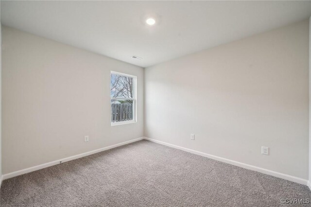 spare room with baseboards, visible vents, and carpet floors